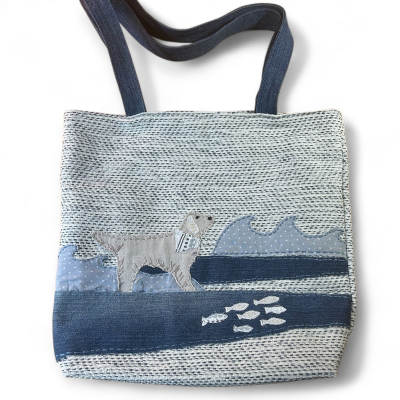 The Pupperfish Enhance your tote experience with our hand-stitched golden retriever tote bag! Made from vintage fabrics, this bag is perfect for dog lovers and eco-conscious fashionistas. Embrace the playful charm of this unique bag featuring a retriever swimming in the waves. 