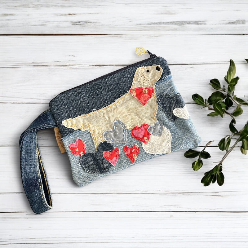 The Pupperfish Handmade golden retriever zipper pouch with hand embroidered golden retriever in hearts. Materials are a mix of vintage fabrics and upcycled denim.